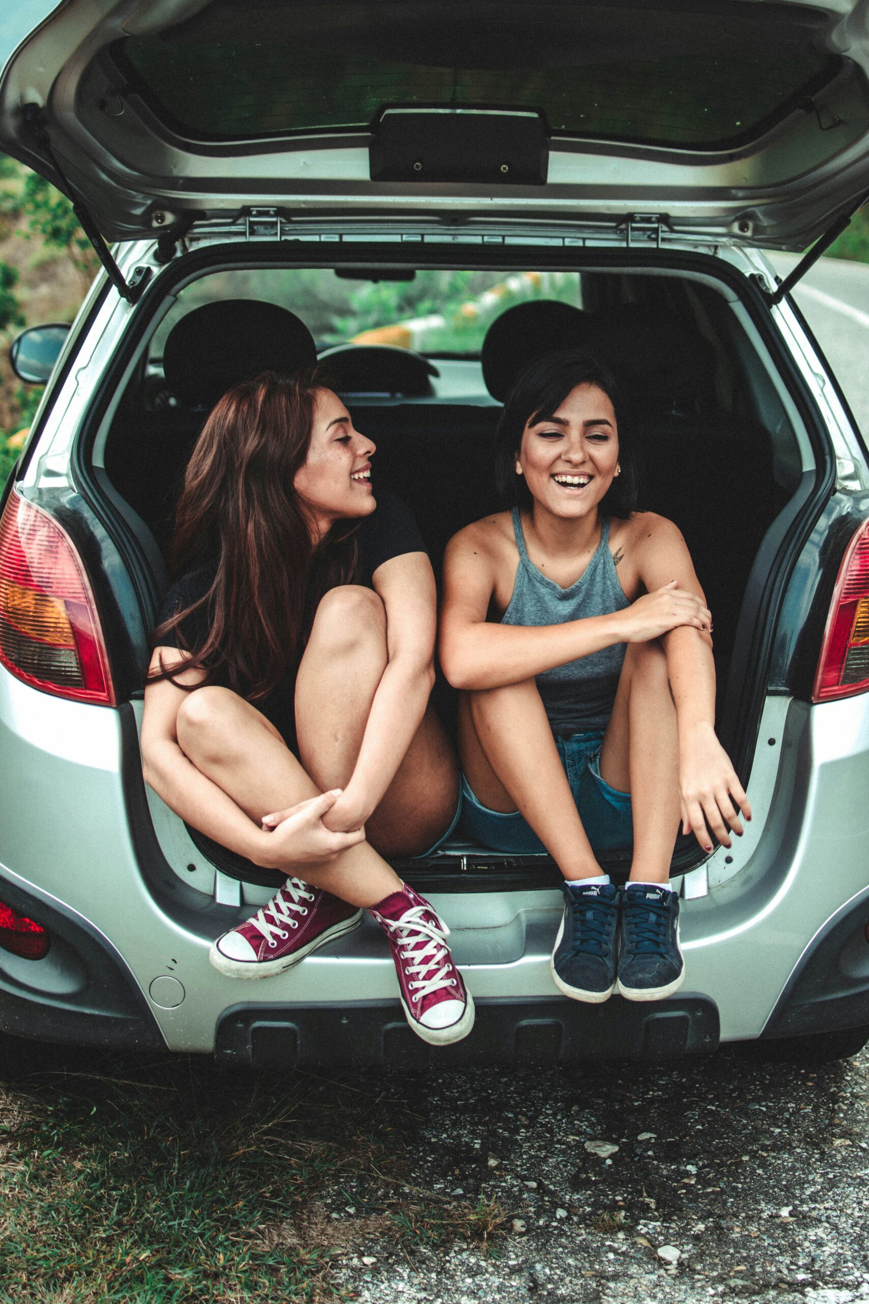 Two women sitting in the boot of a car